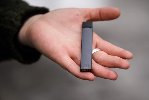 Gray Juul device in a hand