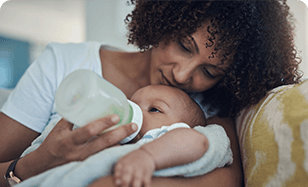 Woman holding and feeding a baby