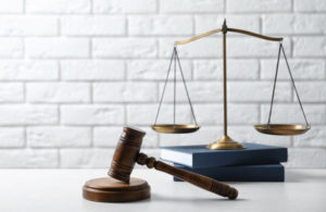 A gavel and the scales of justice sit on a counter