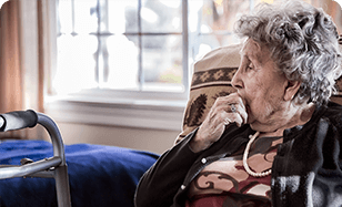 A woman sits in a chair in a nursing home