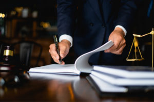A lawyer signs an asbestos settlement document