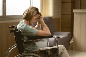 A woman sits in a wheelchair in a nursing home