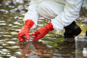 A scientist collects water for testing