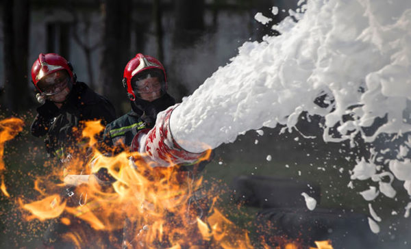 A firefighter sprays AFFF on a fire
