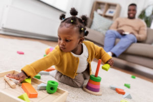 A toddler with Erb's palsy plays with toys