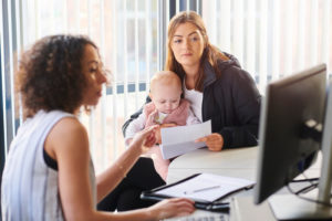 showing a planner advising a woman holding a baby