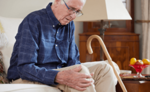 A nursing home resident grabs his knee in pain