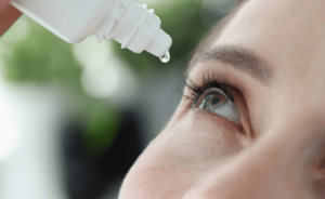 A person uses EzriCare Artificial Tears eye drops