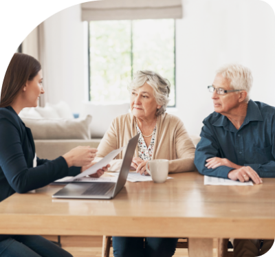 An older couple sitting at a table going over documents with an attorney.