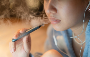 A teenager using a vape pen.