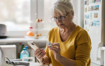 An woman looks at a pill bottle