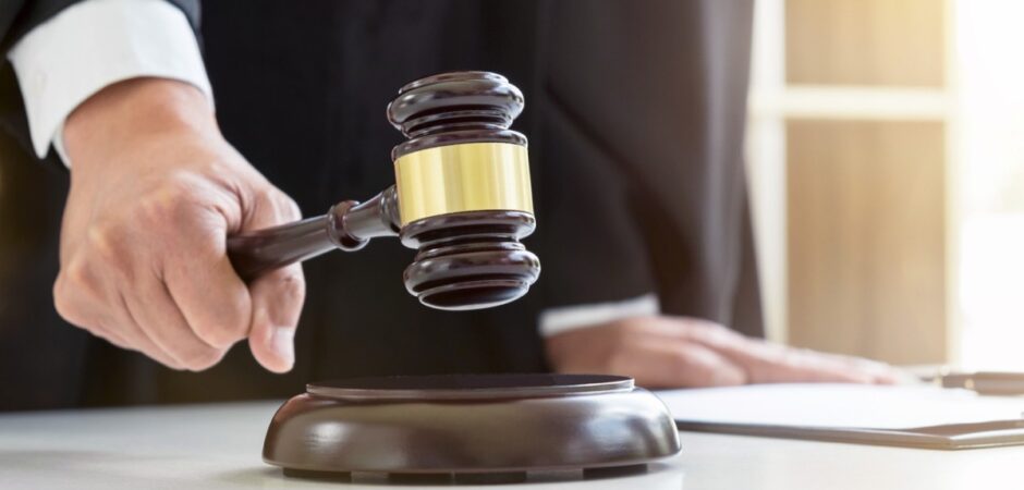 A judge strikes a gavel on a desk